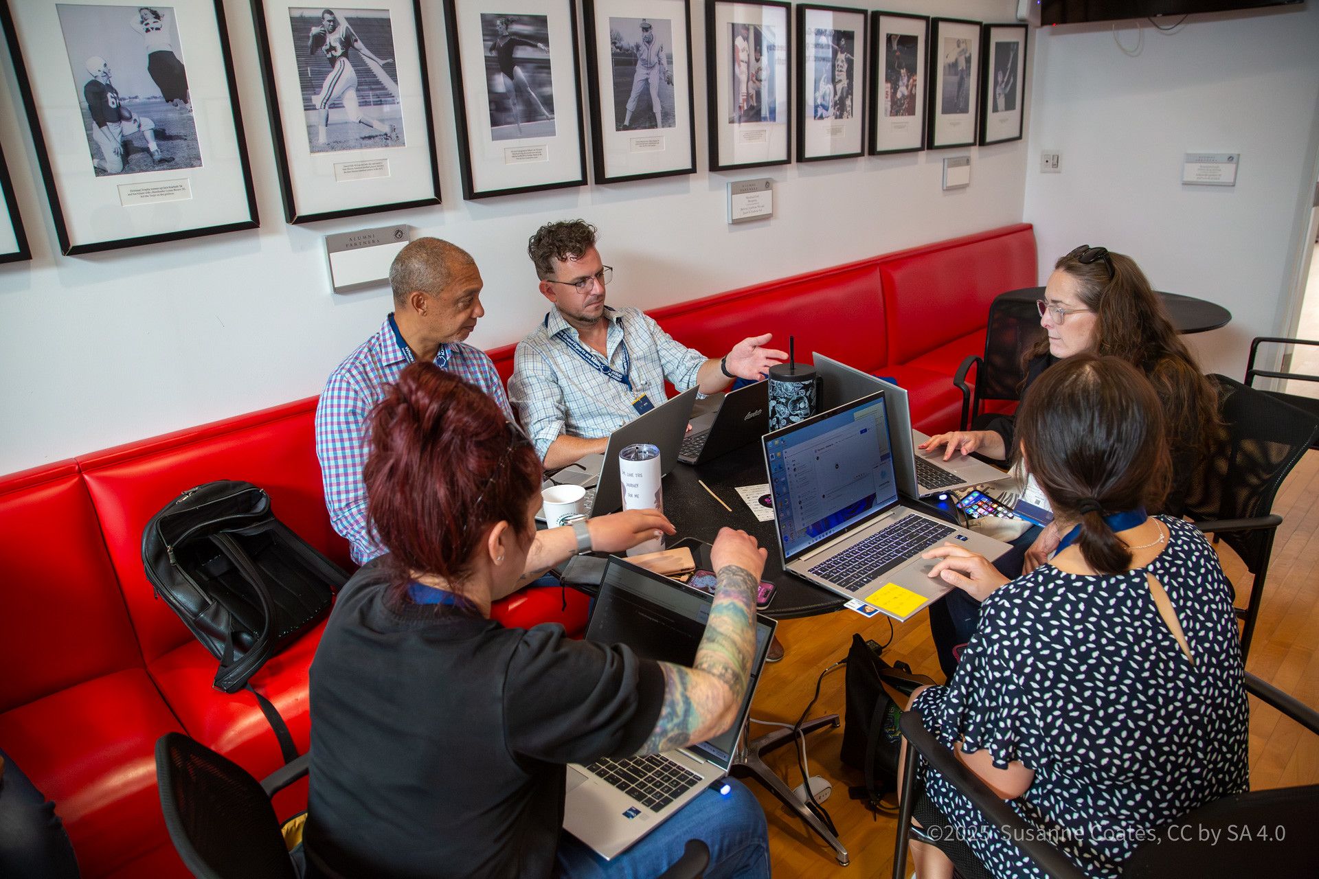 Three business professionals discussing paperwork and reviewing documents in a corporate office setting.