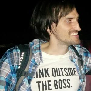 Unkempt smiling white man in a Think Outside the Boss t-shirt.